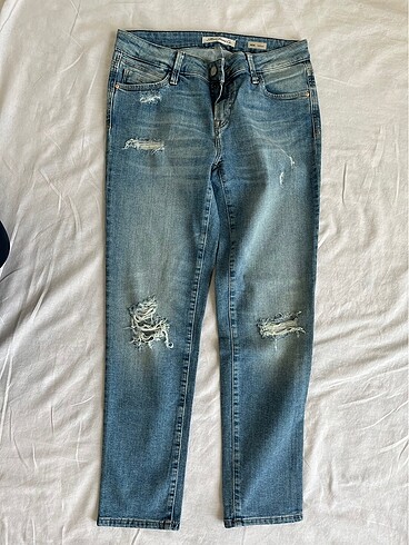 Mavi jeans yırtıkları olan kot pantolon,orta bel