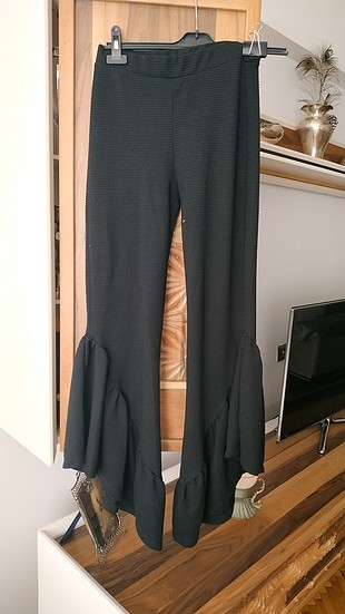paçaları volanlı siyah pantolon.