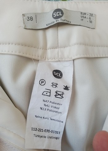38 Beden Deri görünümlü krem rengi pantolon.