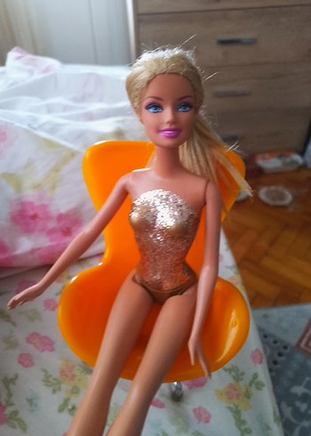 Parlak turuncu sandalyede Barbie bebek