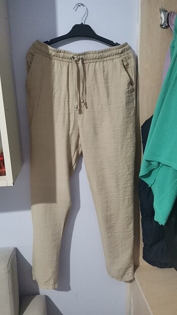 Kumaşı püfür püfür krem renginde bir kumaş pantolon