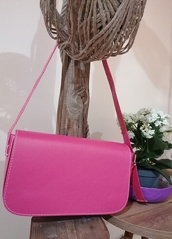 Pembe kol çantası, duruşu yok güzel. 