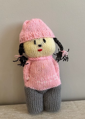 Pembe örgü şapkalı oyuncak bebek