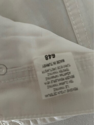 Diğer Sıfır, etiketli yüzde 94 keten ve likralı beyaz jean pantolon.