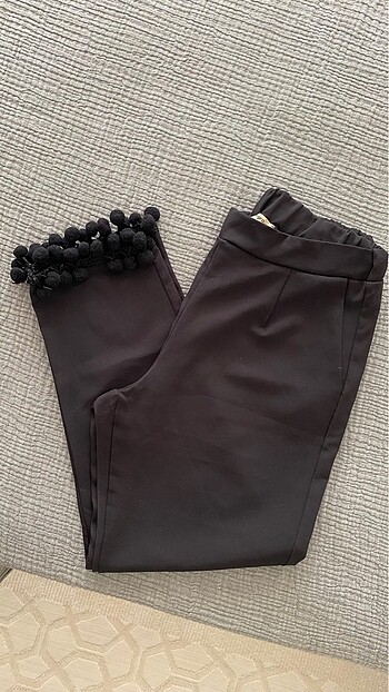 Paçaları ponponlu siyah kumaş pantolon