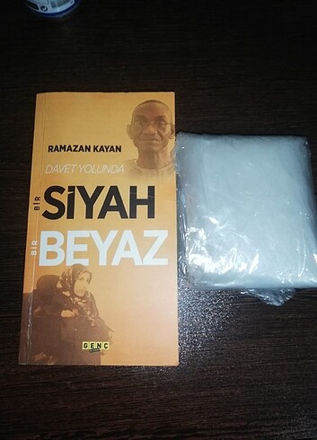 Siyah beyaz kitap yaninda yagmurluk hediye